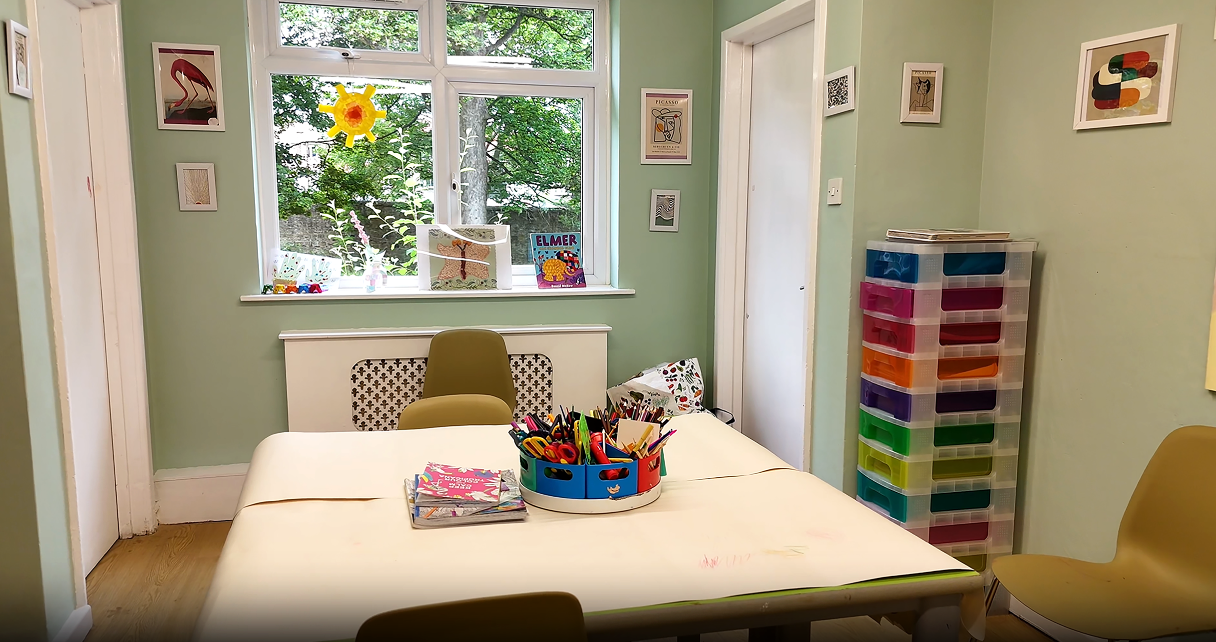 Art room with tables and chairs with art supplies pens and pencils on the table