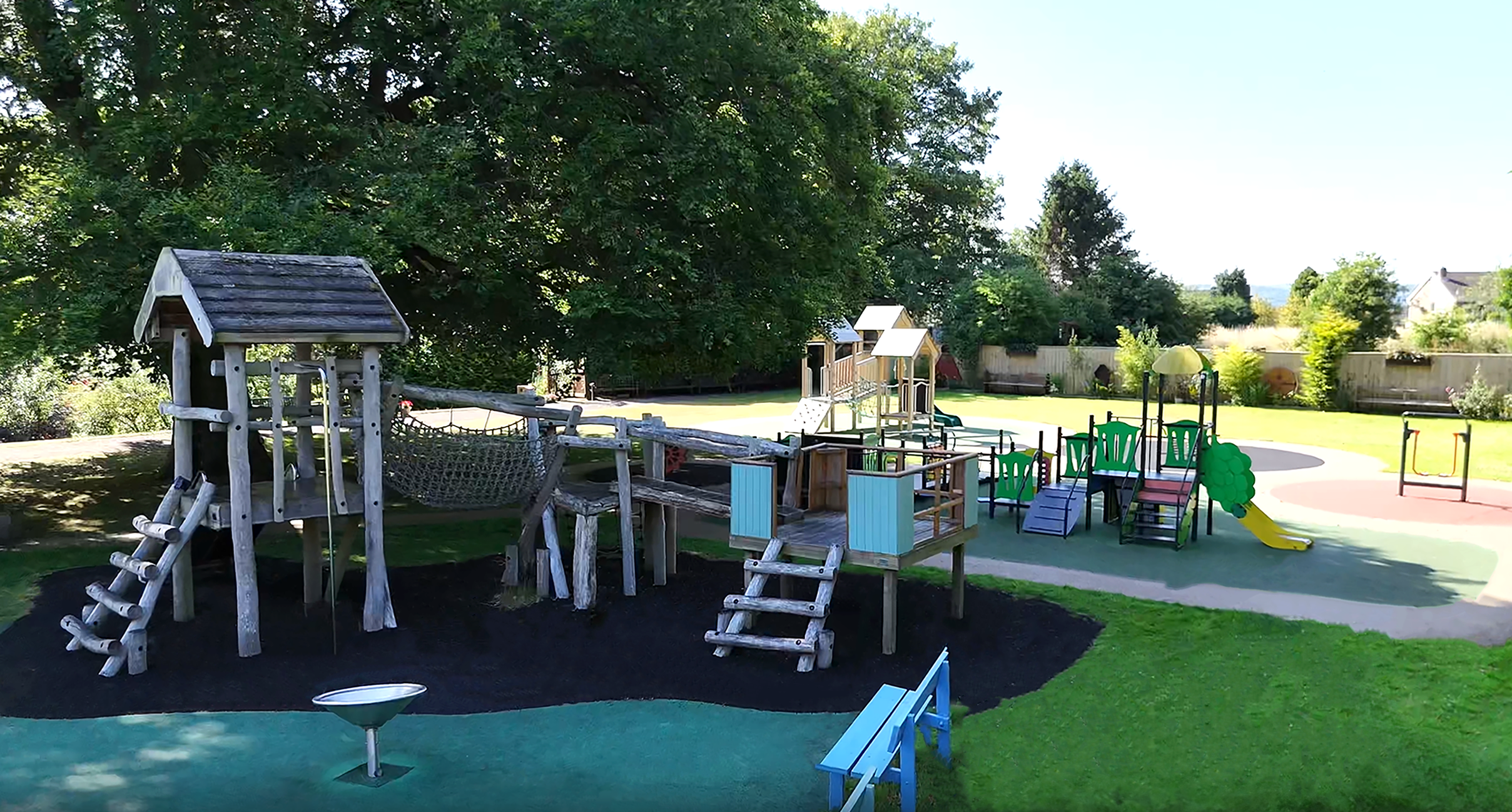 Outdoor play area with wooden climbing frames.