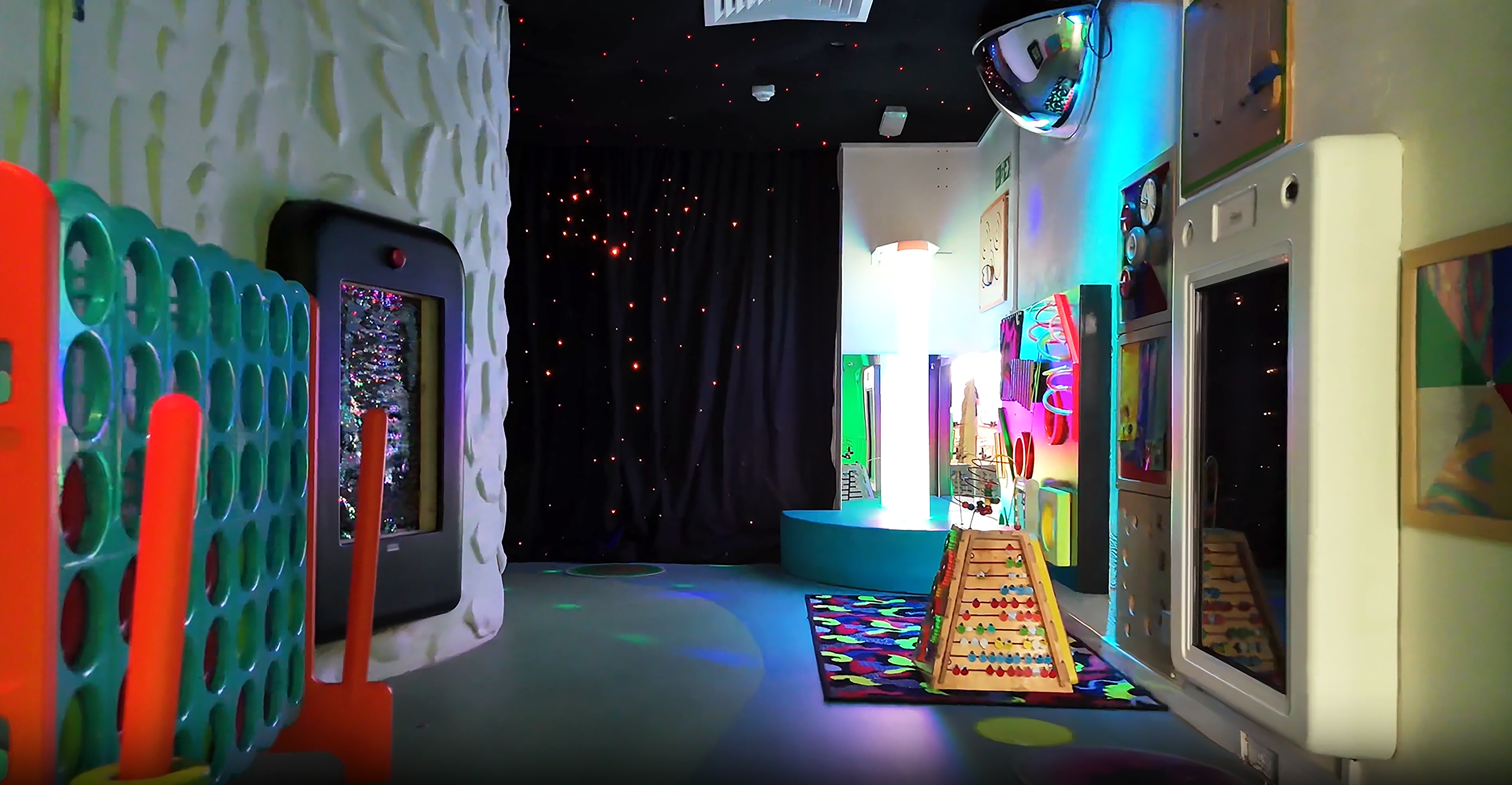 sensory cave and corridor with dark walls and lots of bright toys.