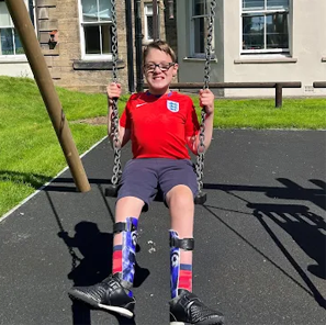 Young boy on swing outside in the sun
